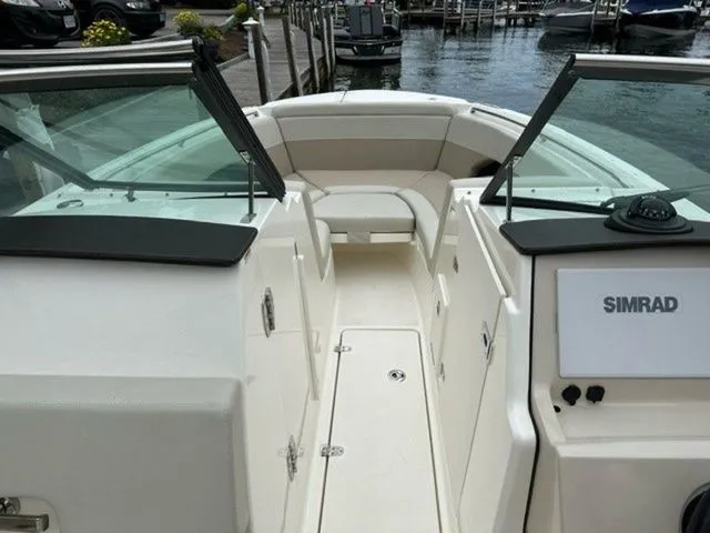 Slide: The Image of 2023 Boston Whaler 240 Vantage boat interior with Simrad navigation system, docked by the water. - 15