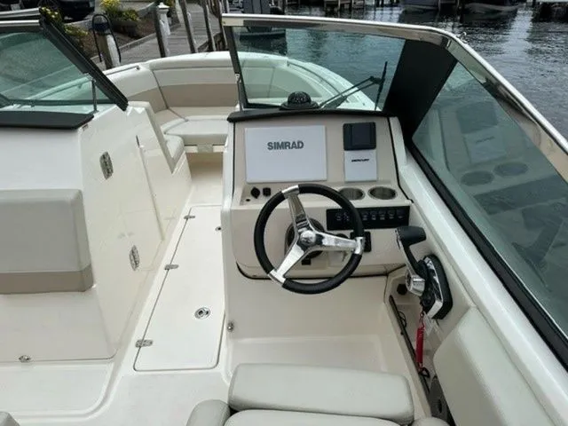 Slide: The Image of 2023 Boston Whaler 240 Vantage boat interior with steering wheel and Simrad navigation system. - 17
