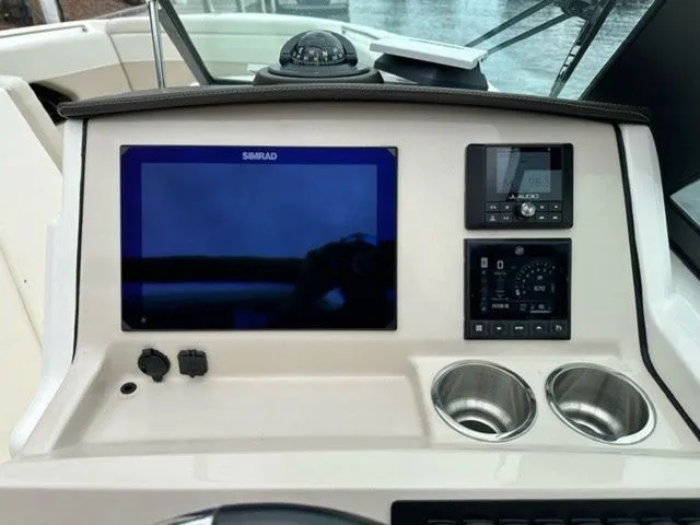 Slide: The Image of 2023 Boston Whaler 240 Vantage dashboard with navigation screen and controls. - 19