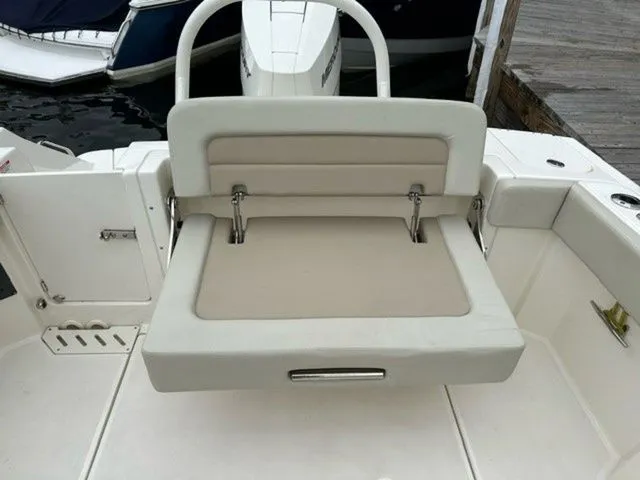 Slide: The Image of 2023 Boston Whaler 240 Vantage boat seat, white upholstery, docked by the water. - 8