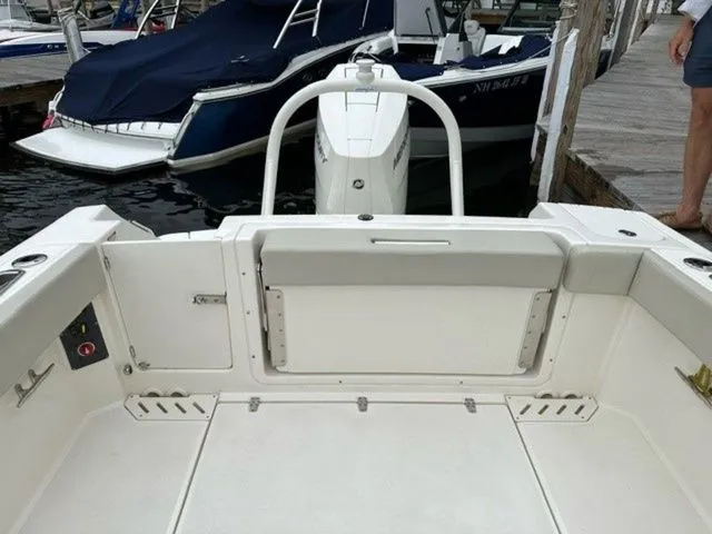 Slide: The Image of 2023 Boston Whaler 240 Vantage boat interior at dock, showcasing seating and storage. - 9