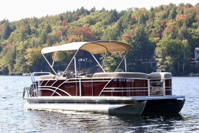 Slide: The Image of 2023 Sylvan 8522 LZ pontoon boat on a scenic lake with autumn foliage. - 1