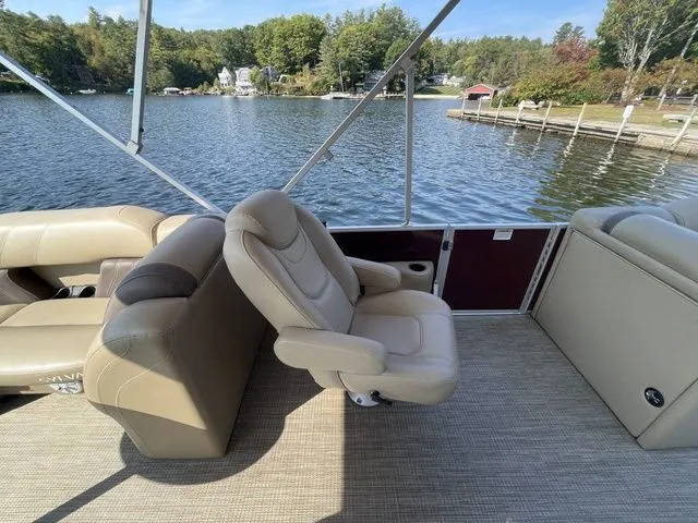 Slide: The Image of 2023 Sylvan 8522 LZ pontoon boat interior with beige seating, lake view, and trees. - 5