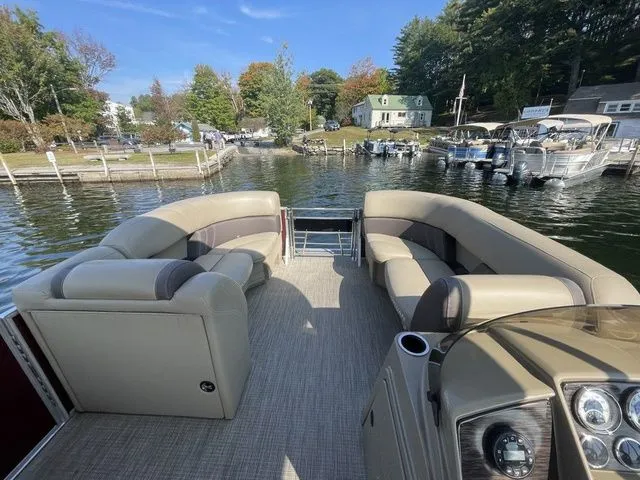 Slide: The Image of 2023 Sylvan 8522 LZ pontoon boat with spacious seating, docked by a scenic lakeside. - 6