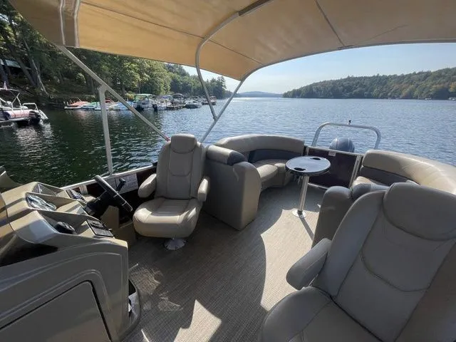 Slide: The Image of 2023 Sylvan 8522 LZ pontoon boat on a scenic lake with comfortable seating. - 8