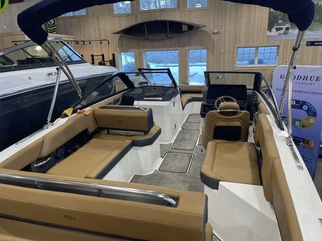 Slide: The Image of 2025 Cobalt R6 boat interior with tan seating and modern design in showroom. - 3