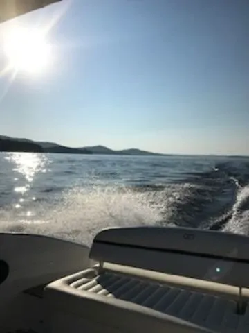 Slide: The Image of Cobalt R7 boat cruising on a sunny day, 2016 model, with scenic water and hills. - 8