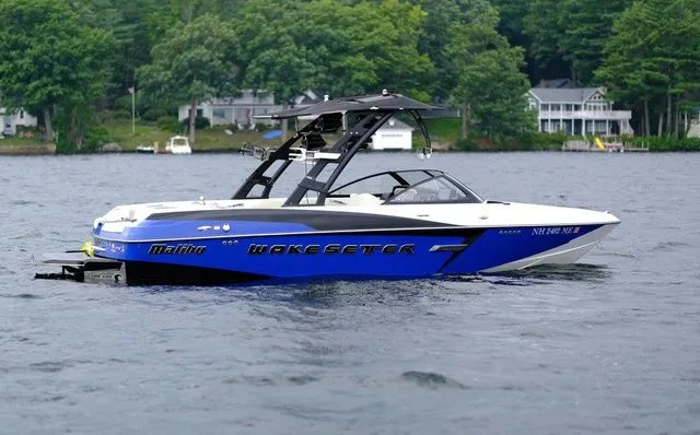 Slide: The Image of 2015 Malibu Wakesetter 22 VLX boat on a lake with lush green shoreline. - 3