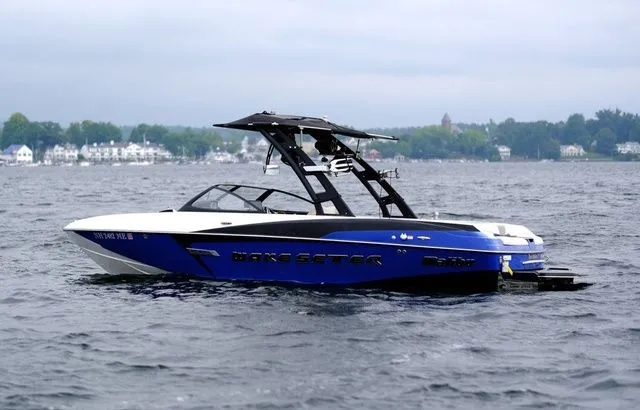 Slide: The Image of 2015 Malibu Wakesetter 22 VLX boat on a lake with a scenic background. - 5