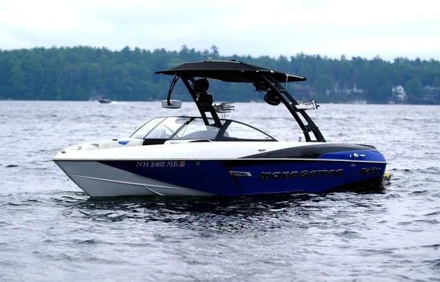 Slide: The Image of 2015 Malibu Wakesetter 22 VLX boat on a lake with forested shoreline. - 7