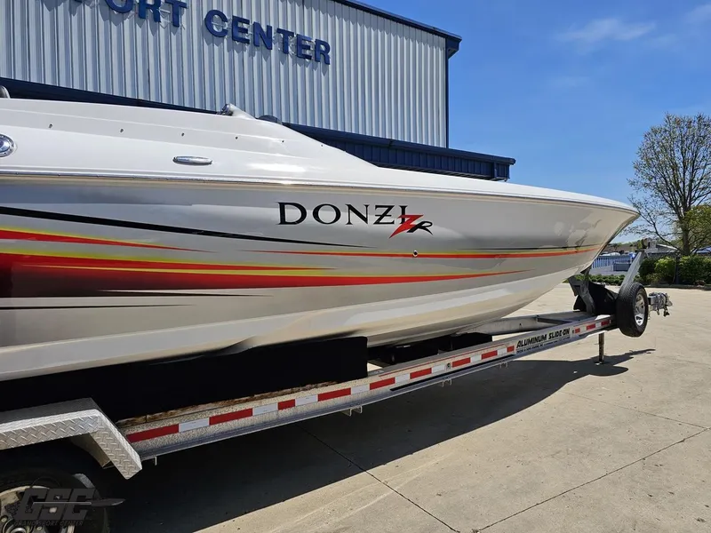 Slide: The Image of 2007 Donzi 38 ZR speedboat on trailer, parked outside a building under clear blue sky. - 11