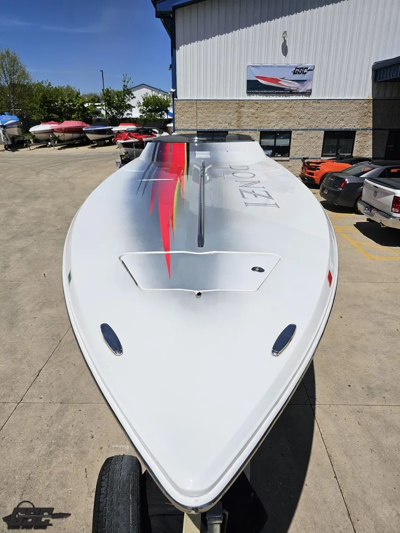 Slide: The Image of 2007 Donzi 38 ZR speedboat with sleek design and vibrant graphics, parked outdoors. - 17