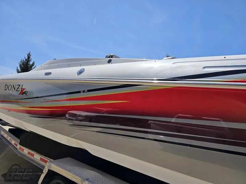 Slide: The Image of 2007 Donzi 38 ZR speedboat with vibrant red and yellow accents on a trailer. - 25