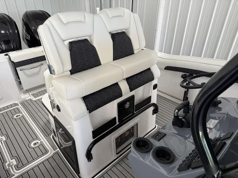 Slide: The Image of 2025 Tidewater 282 CC Adventure boat interior with dual white and black cushioned seats. - 15