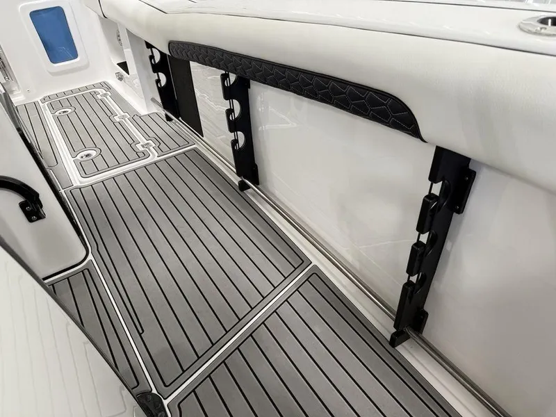 Slide: The Image of 2025 Tidewater 282 CC Adventure boat interior with sleek, modern flooring and storage features. - 16