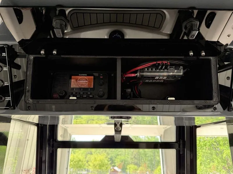 Slide: The Image of 2025 Tidewater 282 CC Adventure boat dashboard with electronic equipment and storage compartment. - 24