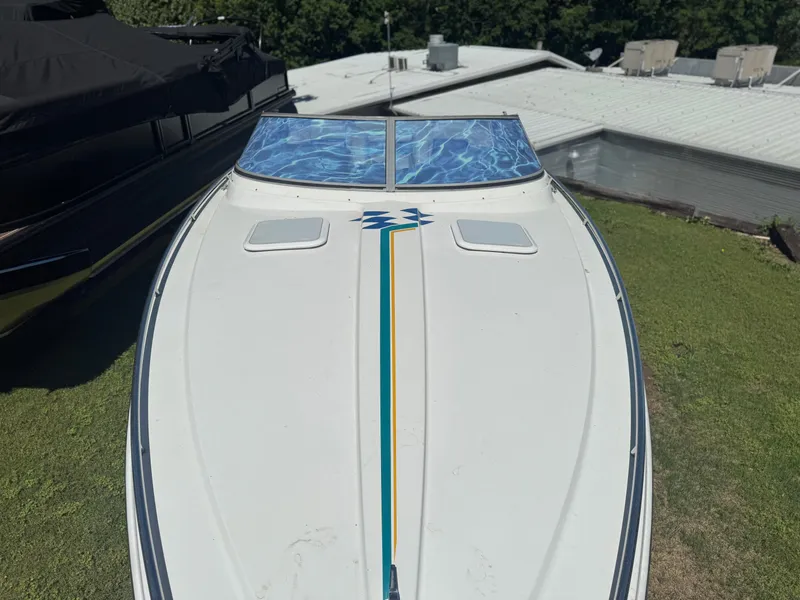 Slide: The Image of 2000 Formula 271 FASTech boat with sleek design, parked on grass near buildings. - 15