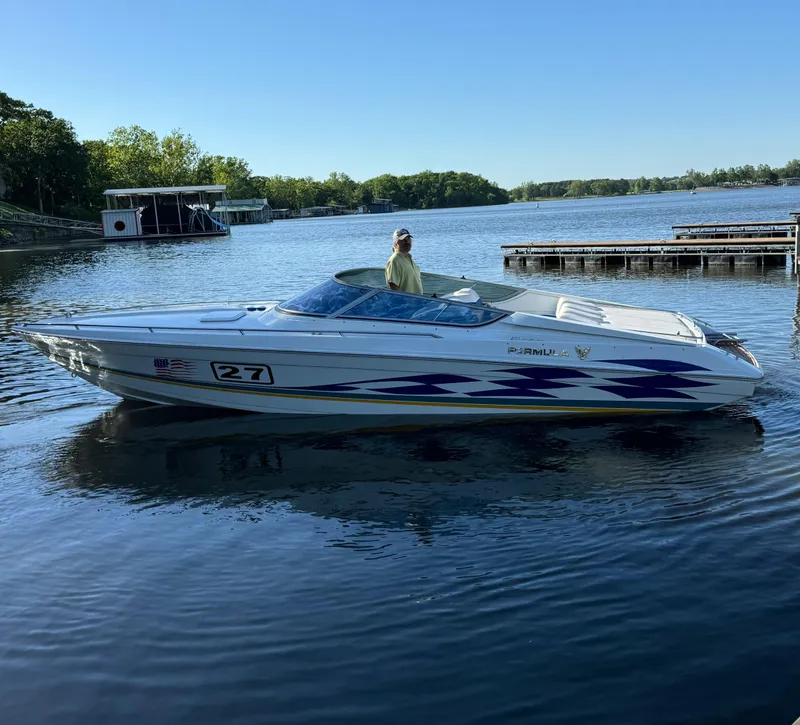 Slide: The Image of 2000 Formula 271 FASTech boat on a calm lake near docks. - 18