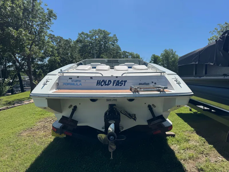 Slide: The Image of 2000 Formula 271 FASTech boat, rear view, parked on grass under clear blue sky. - 3