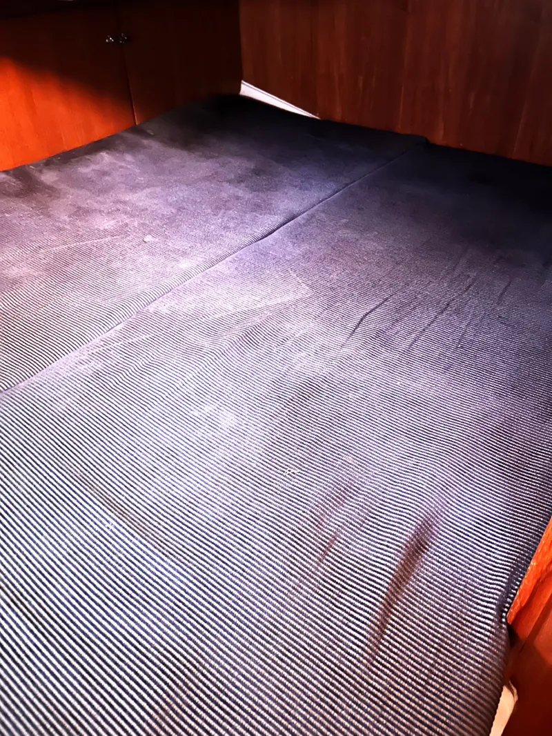 Slide: The Image of Interior cabin bed of 2005 Hunter 33 sailboat with dark fabric cover. - 10