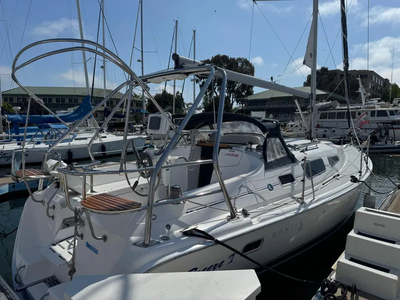 Slide: The Image of 2005 Hunter 33 sailboat docked at marina, featuring sleek design and spacious deck. - 2