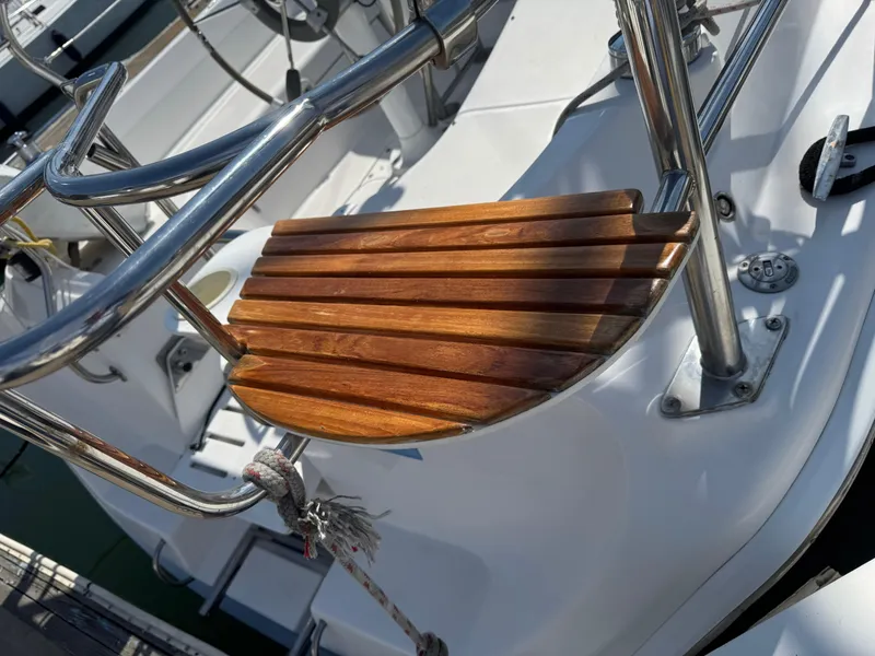 Slide: The Image of Wooden seat on a 2005 Hunter 33 sailboat, featuring stainless steel railings. - 4