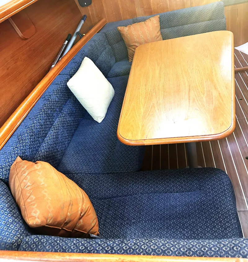 Slide: The Image of Interior of 2005 Hunter 33 sailboat with cushioned seating and wooden table. - 6