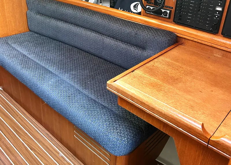 Slide: The Image of Interior of a 2005 Hunter 33 sailboat with blue cushioned seating and wooden table. - 7