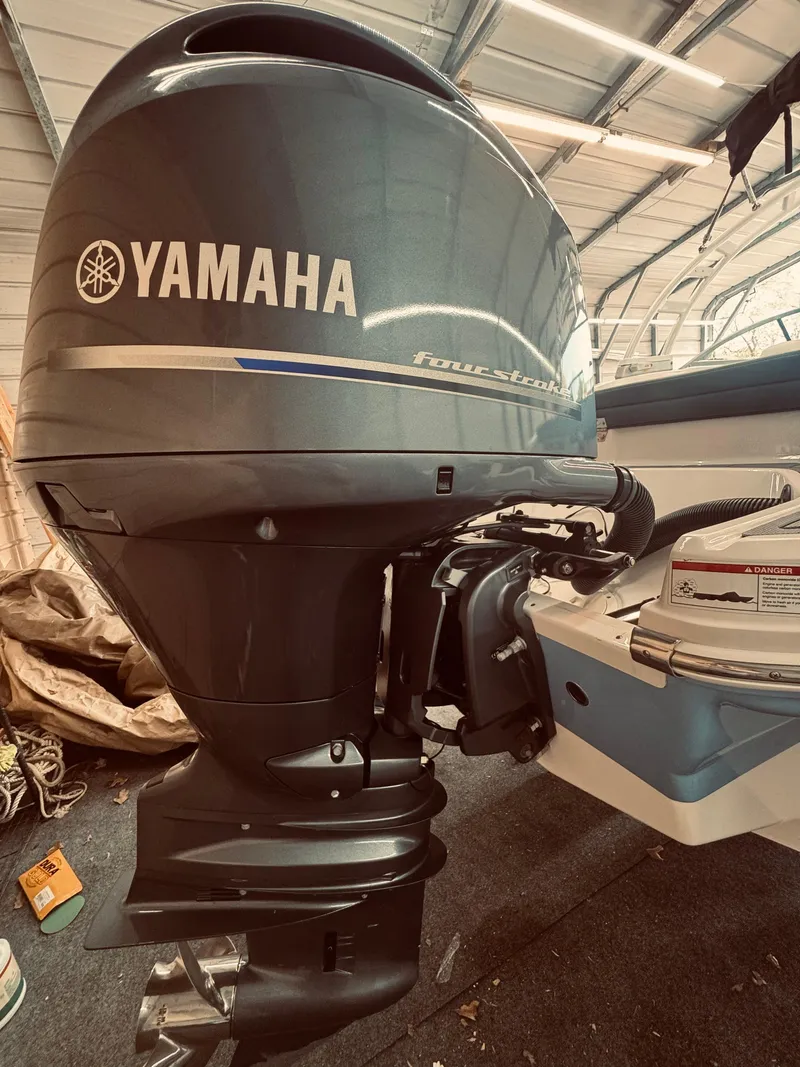 Slide: The Image of 2023 Chaparral 21 SSi OB with Yamaha outboard motor in a garage setting. - 10
