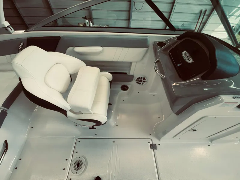 Slide: The Image of 2023 Chaparral 21 SSi OB boat interior with white captain's seat and modern dashboard. - 13
