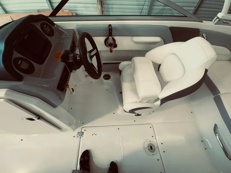 Slide: The Image of 2023 Chaparral 21 SSi OB boat interior with steering wheel and white seating. - 14