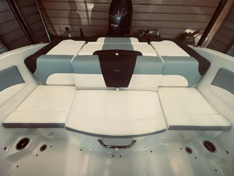Slide: The Image of 2023 Chaparral 21 SSi OB boat interior with cushioned seating and outboard motor. - 16