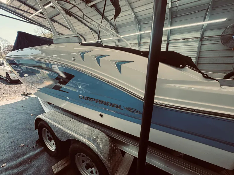 Slide: The Image of 2023 Chaparral 21 SSi OB boat on trailer in a garage setting. - 2