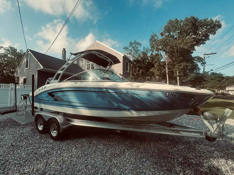 Slide: The Image of 2023 Chaparral 21 SSi OB boat on trailer, parked in a residential driveway. - 24