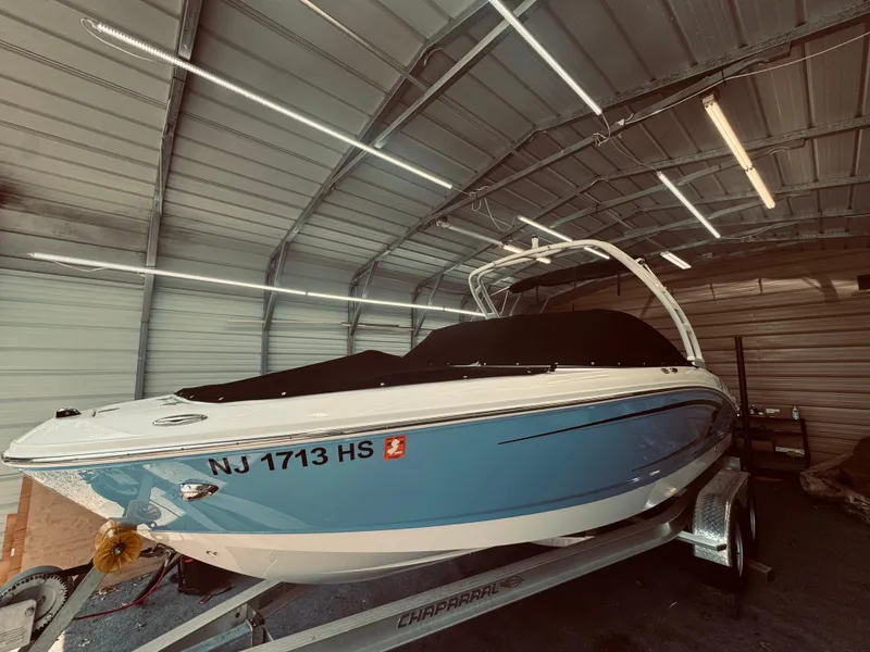 Slide: The Image of 2023 Chaparral 21 SSi OB boat in garage, blue hull, on trailer. - 4