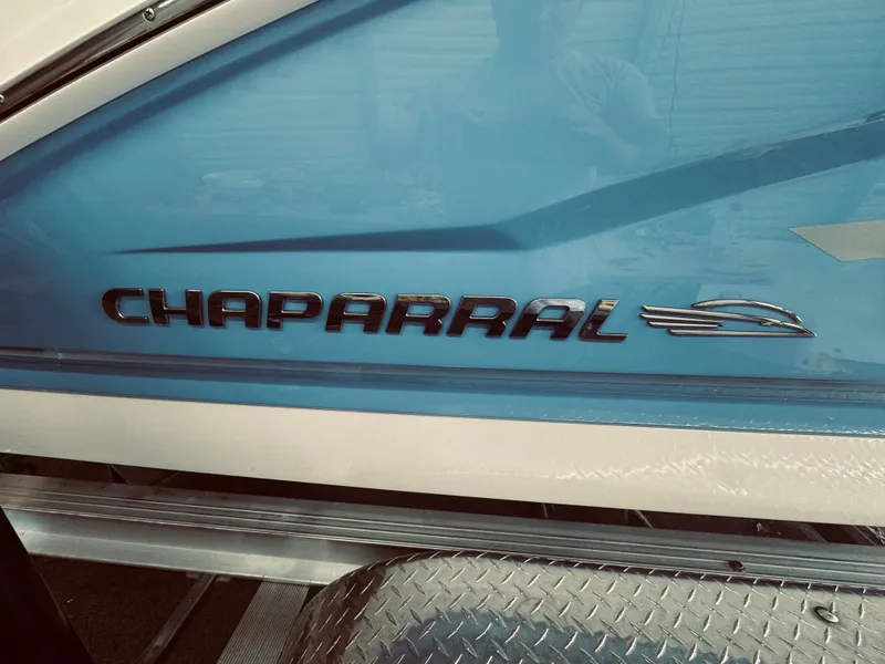 Slide: The Image of 2023 Chaparral 21 SSi OB boat with blue and white exterior detailing. - 5