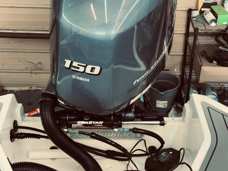 Slide: The Image of 2023 Chaparral 21 SSi OB with Yamaha 150 outboard motor in a garage setting. - 9