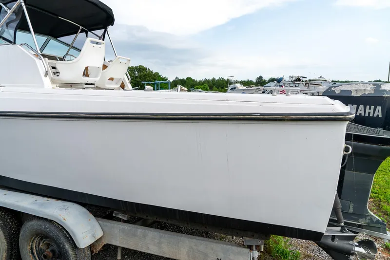 Slide: The Image of 1986 Aquasport 250 Express Fisherman boat on trailer, side view, outdoors. - 10