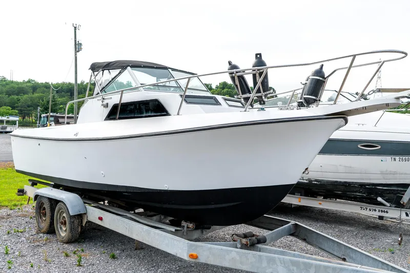 Slide: The Image of 1986 Aquasport 250 Express Fisherman boat on trailer, white hull, outdoor setting. - 2