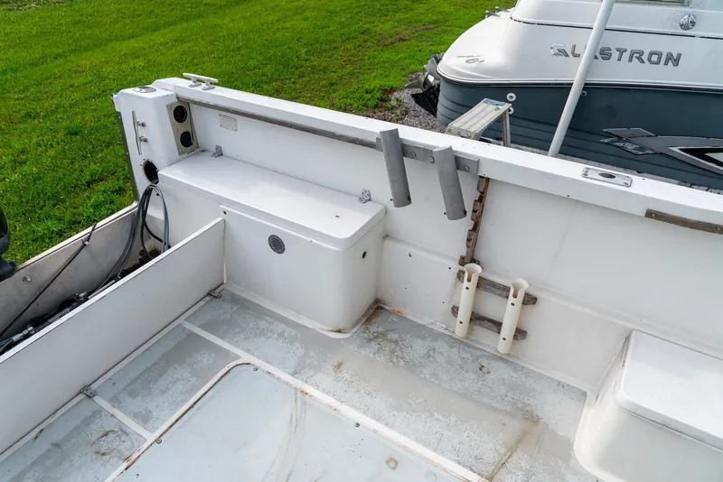 Slide: The Image of 1986 Aquasport 250 Express Fisherman boat interior with storage and seating. - 20