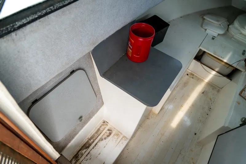 Slide: The Image of 1986 Aquasport 250 Express Fisherman cabin interior with storage and seating area. - 26