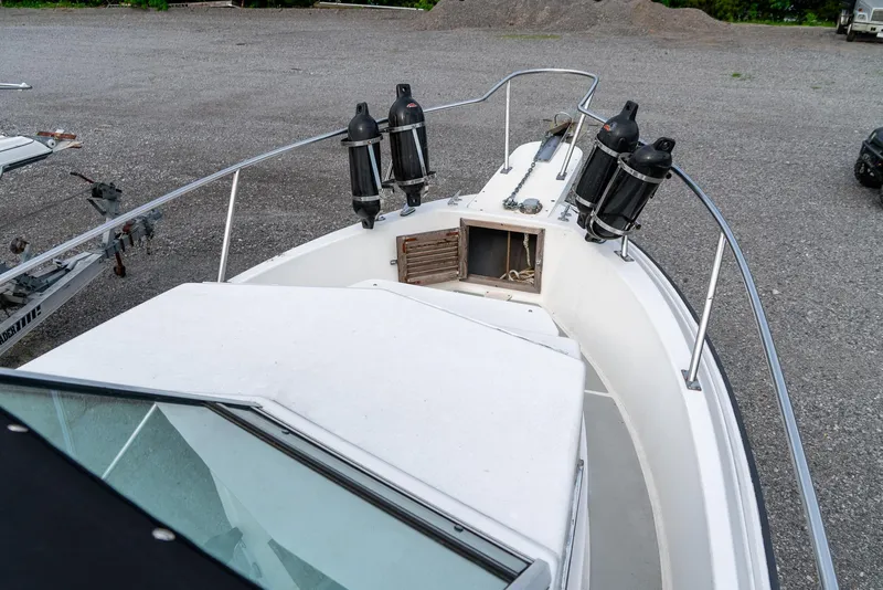 Slide: The Image of 1986 Aquasport 250 Express Fisherman boat deck with railing and anchor storage. - 30