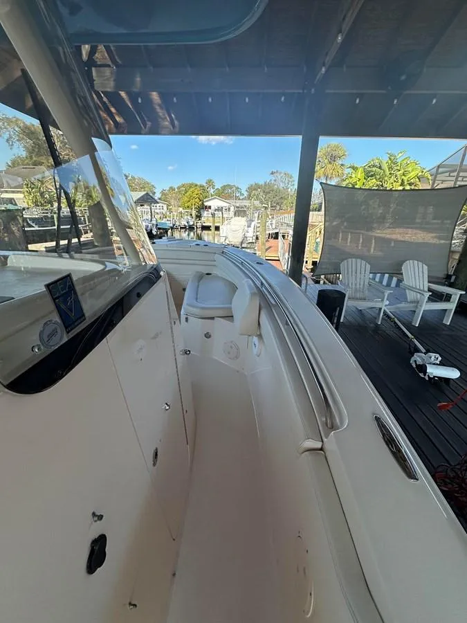 Slide: The Image of 2020 Grady-White Canyon 306 boat docked, showcasing sleek design and spacious deck area. - 10