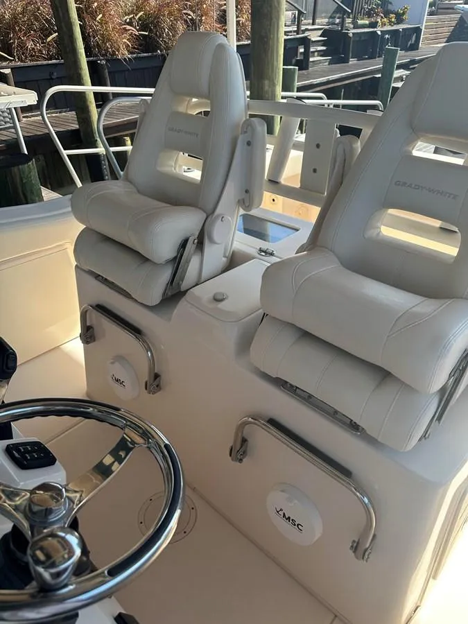 Slide: The Image of 2020 Grady-White Canyon 306 boat interior with dual white captain's chairs and steering wheel. - 13
