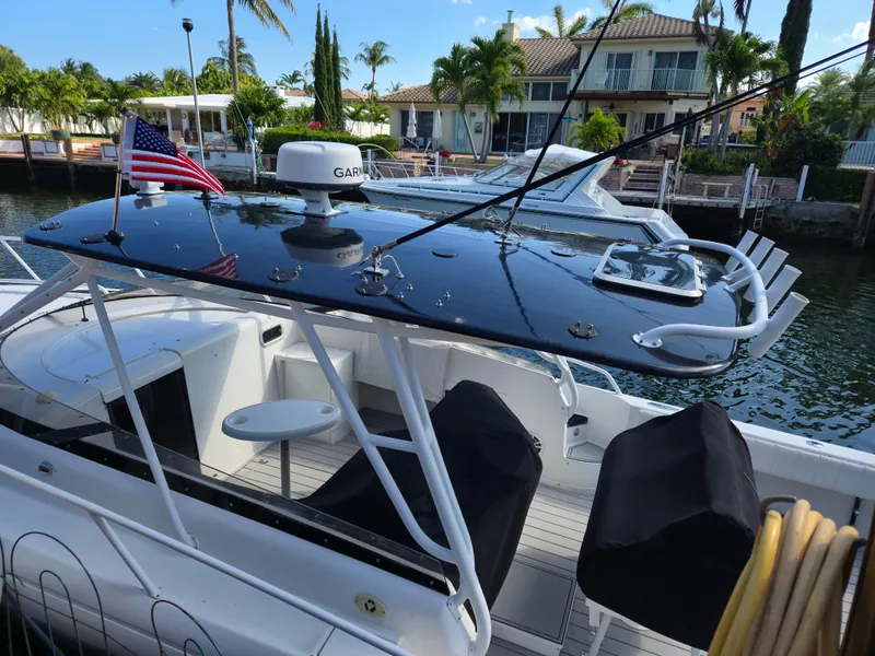 Slide: The Image of 2002 Intrepid 377 Walkaround boat docked, featuring sleek design and American flag. - 11