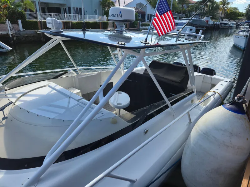 Slide: The Image of 2002 Intrepid 377 Walkaround boat docked, featuring sleek design and American flag. - 14