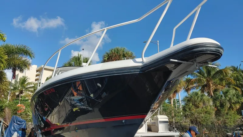 Slide: The Image of 2002 Intrepid 377 Walkaround boat with sleek design, docked under clear blue sky. - 2