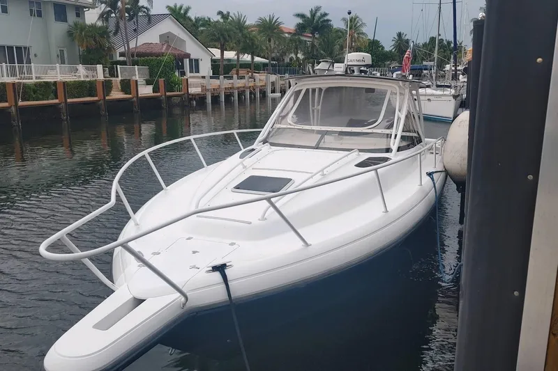 Slide: The Image of 2002 Intrepid 377 Walkaround boat docked in a serene waterfront setting. - 21