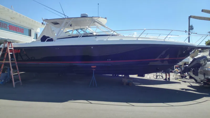 Slide: The Image of 2002 Intrepid 377 Walkaround boat on dry dock, side view under clear blue sky. - 3