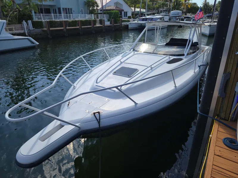 Slide: The Image of 2002 Intrepid 377 Walkaround boat docked in a marina, featuring sleek design and spacious deck. - 4